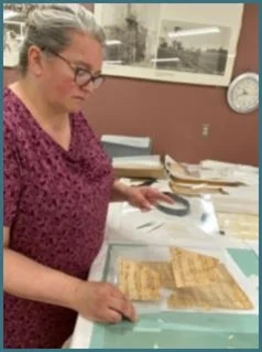 Comparing fragments in Mylar sleeves to puzzle pieces back where they belong.