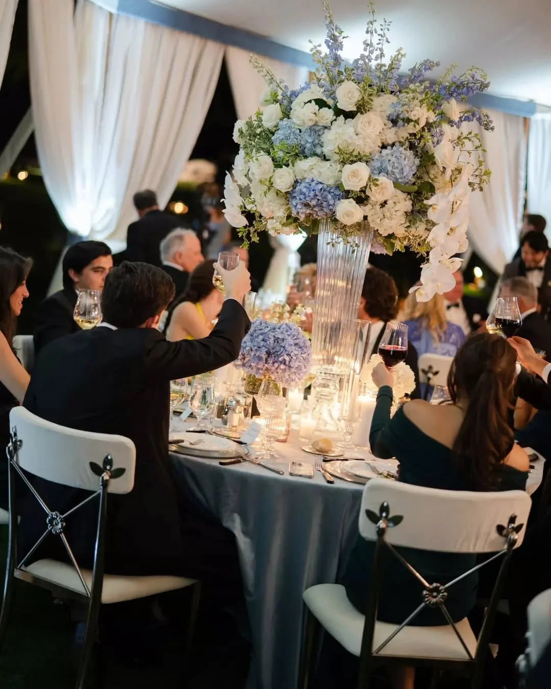 This is what a tented reception looks like when the evening really settles in 🤍

Liz and Richie at @phoenicianscottsdale - Regency Chairs in white and black, candlelight, towering florals by @luxflorist, and a room full of people who didn&rsquo;t wa