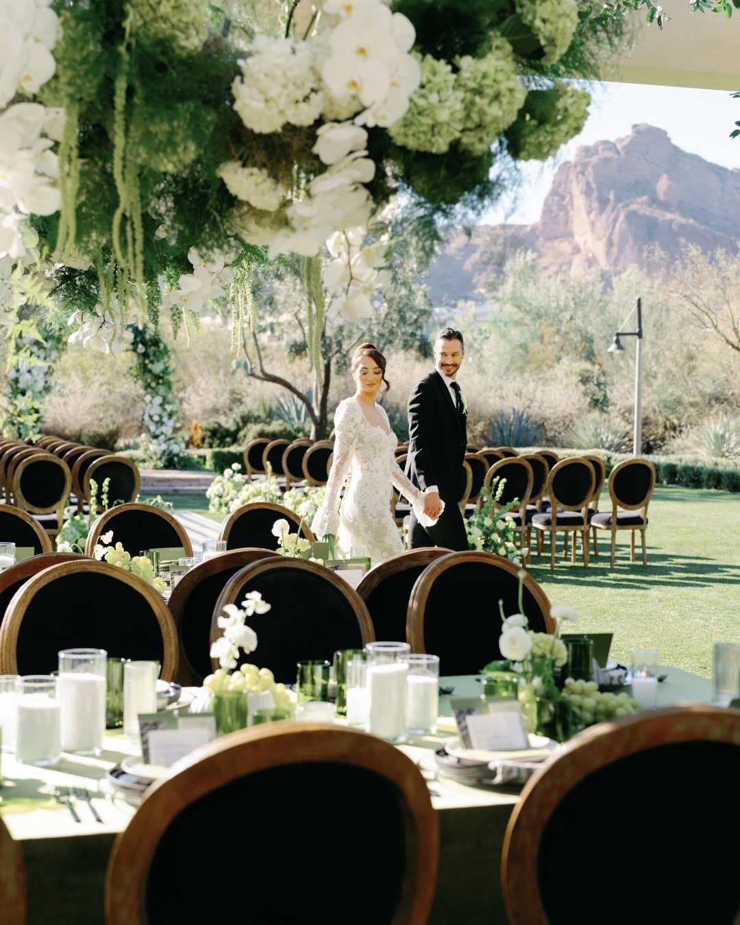 The Leopold Black Dining Chair at El Chorro - warm wood frame, black velvet seat, Camelback Mountain in the background. 🖤

Dark chairs against white florals and an Arizona sky is a combination that never misses. This one was part of an I Do Experien