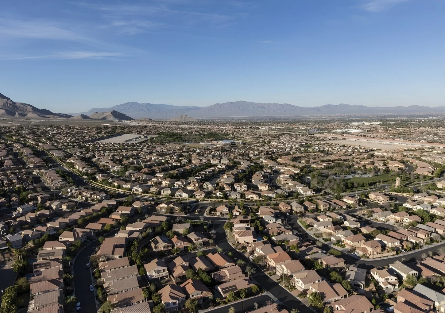 Aerial view of a Mesquite Nevada neighborhood showing residential homes, curved streets, and surrounding desert mountains.