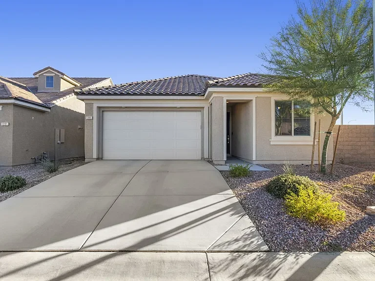 Exterior of 1395 Mariposa Way in Mesquite, NV, featuring a single-story stucco home with a two-car garage, tile roof, and low-maintenance desert landscaping.