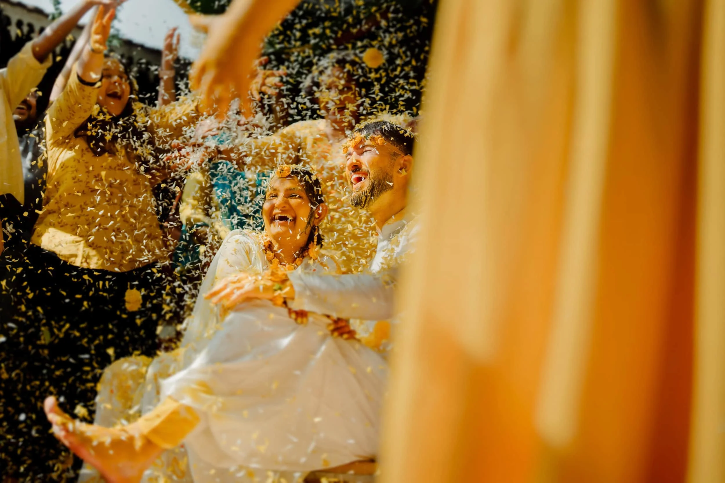 People celebrating with rice and flower crowns, smiling and enjoying the event.