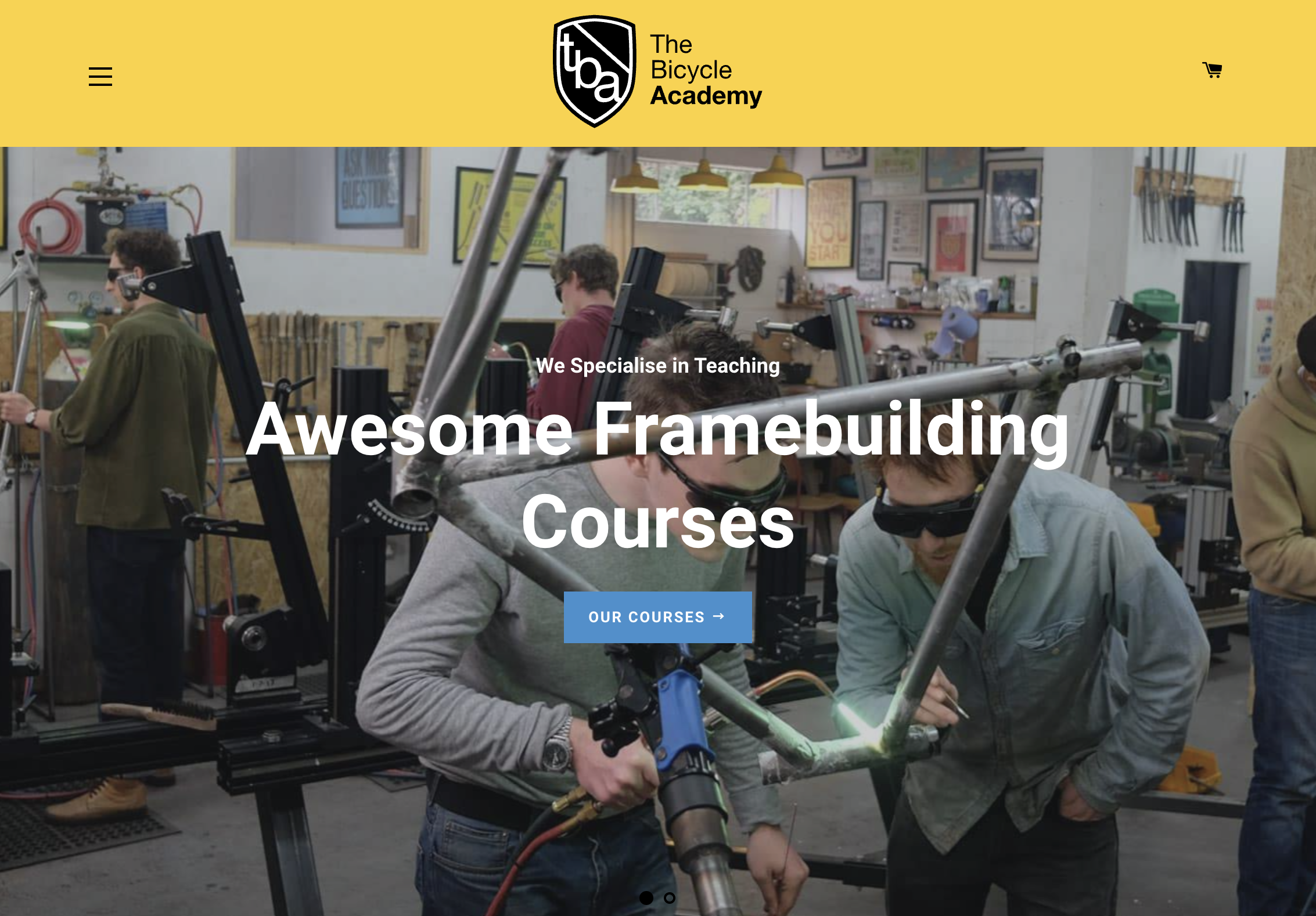 Bicycle Academy workshop with two people building a bike frame.