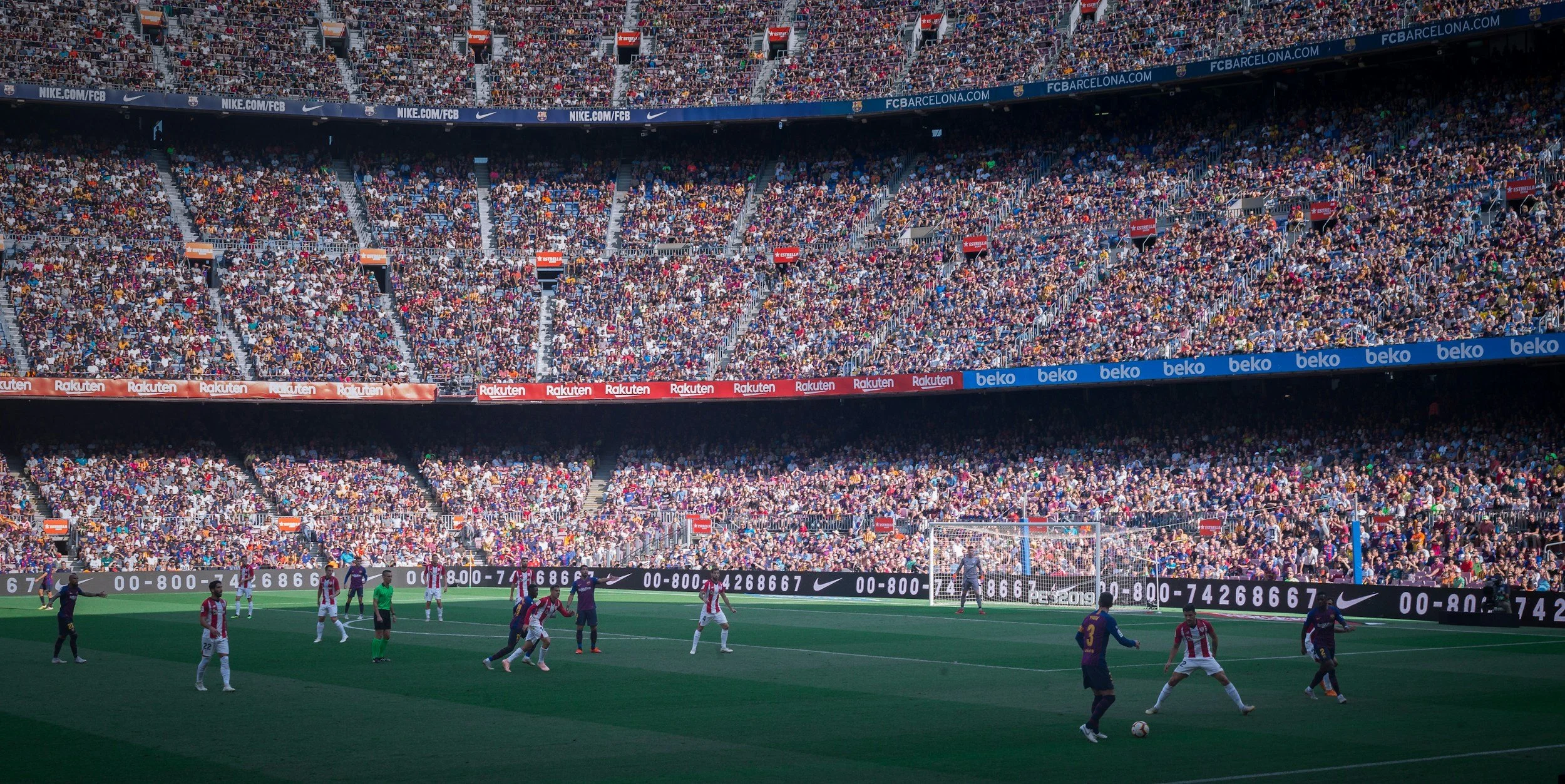 Soccer match in a large stadium with thousands of spectators in the stands.