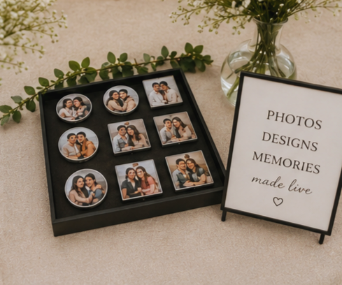 A display of nine custom memorabilia buttons next to a small sign that reads 'Photos, Designs, Memories made live'.