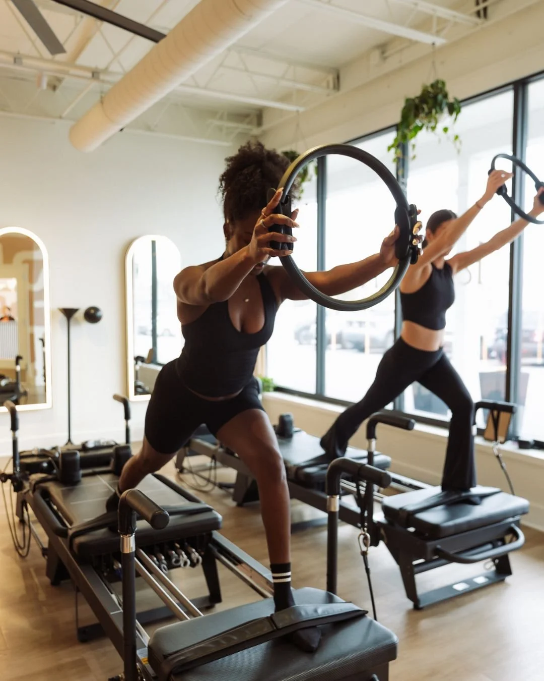 Two women working out at La Forme Modern Reformer Pilates