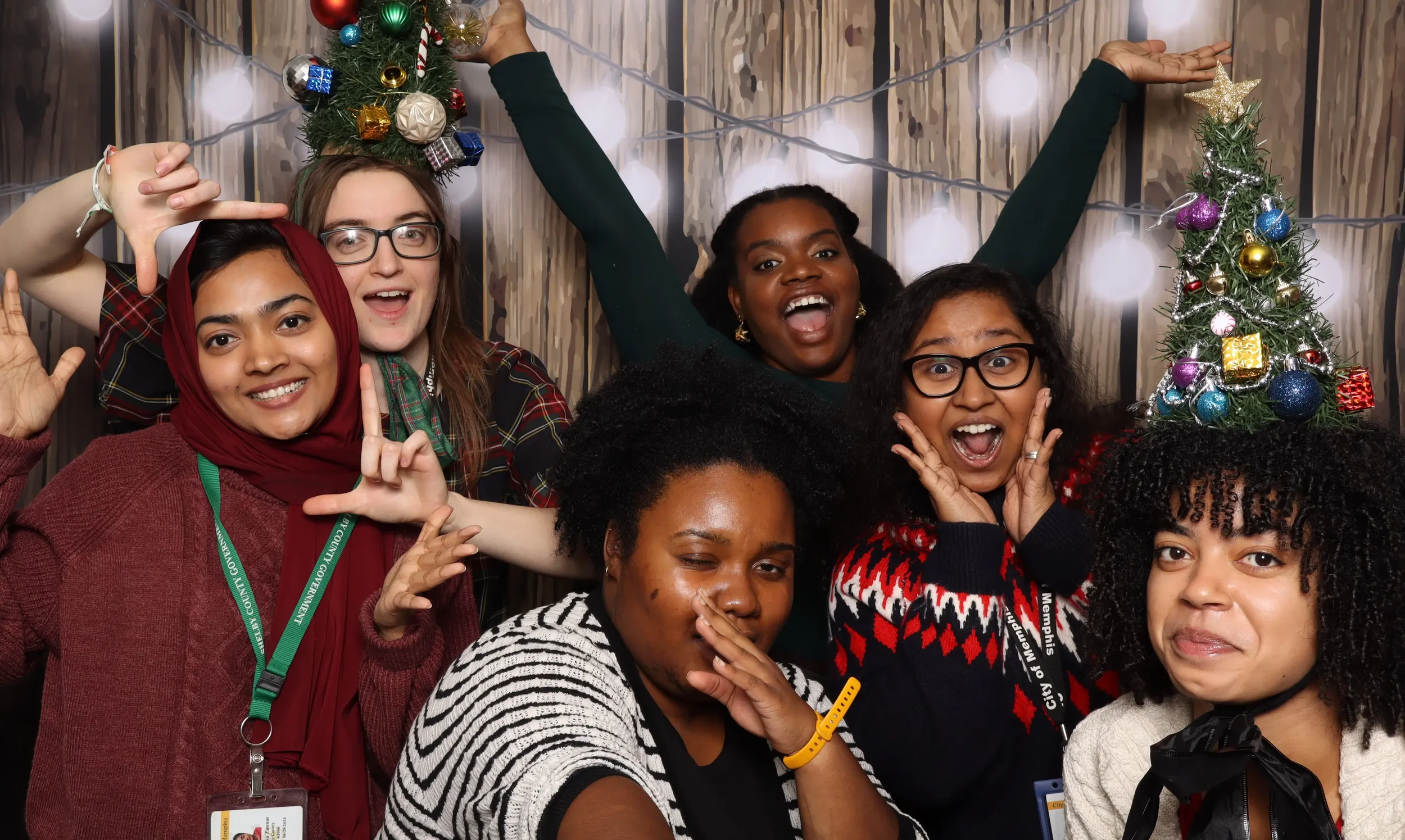 women in holiday sweaters having fun in Memphis Photo Booth