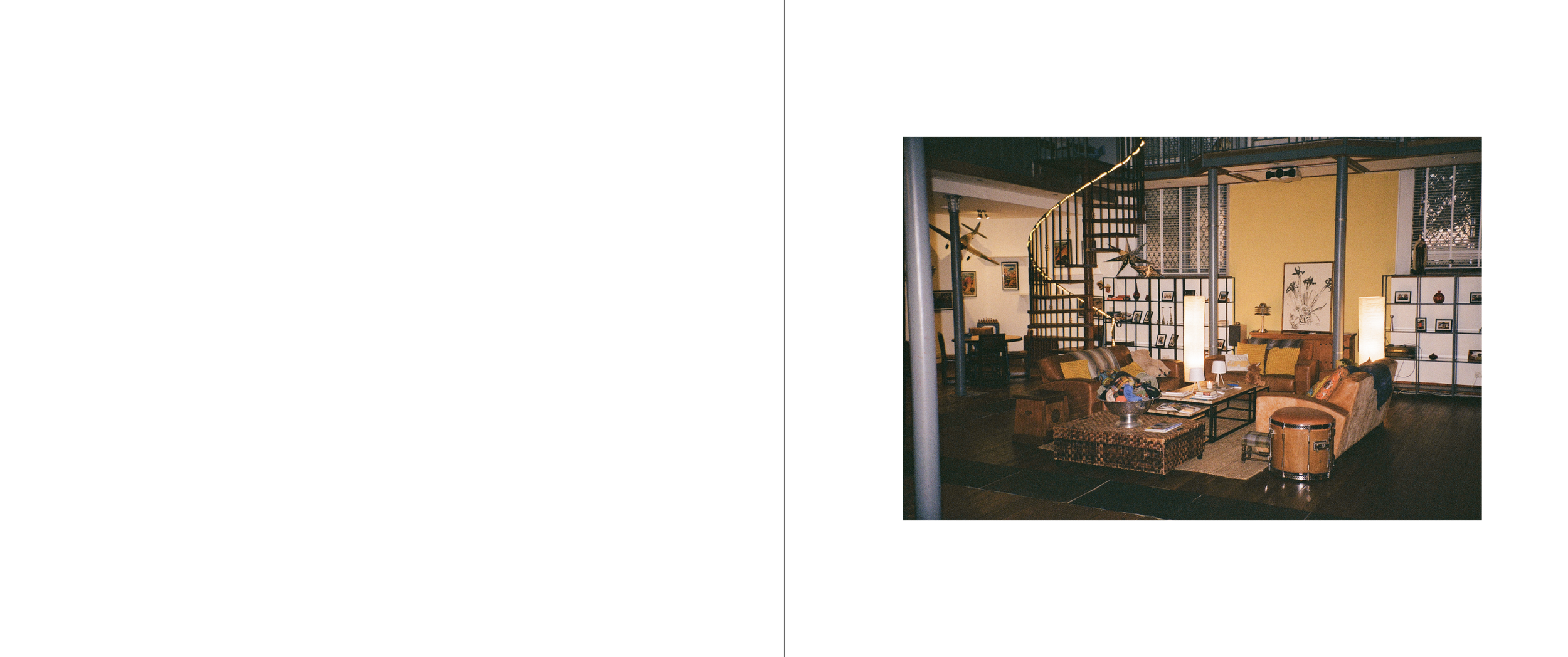 Living room with yellow and white walls, a spiral staircase, various furniture including sofas, armchairs, and coffee tables, and decorative items like picture frames and lamps.