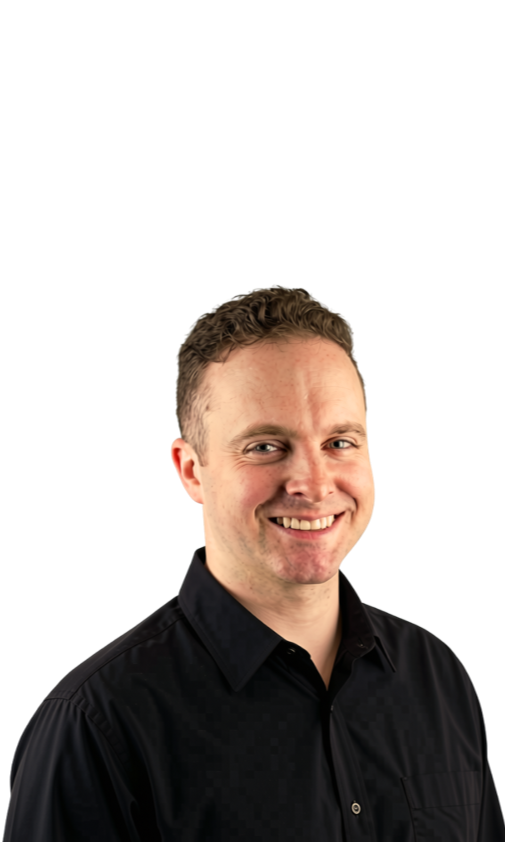 Smiling man in black dress shirt with short light brown hair, photographed against a plain background.