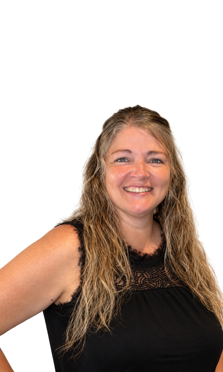 A woman with long wavy blond hair, smiling and wearing a black sleeveless top with lace detail, standing against a purple and black background.