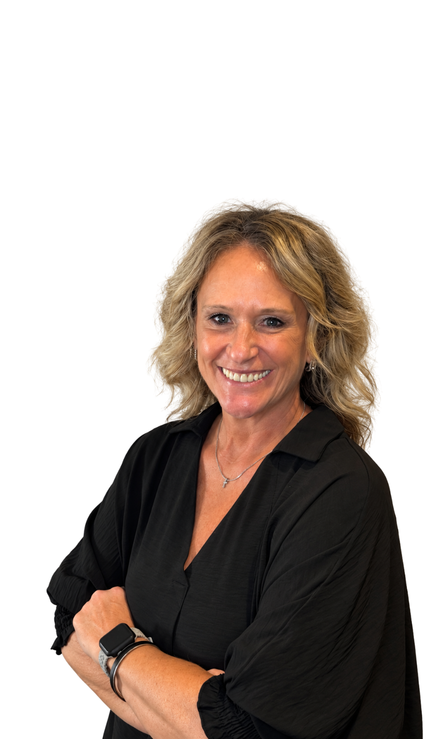 A smiling blonde woman wearing a black blouse, with her arms crossed, wearing a smartwatch and a necklace with a cross pendant.