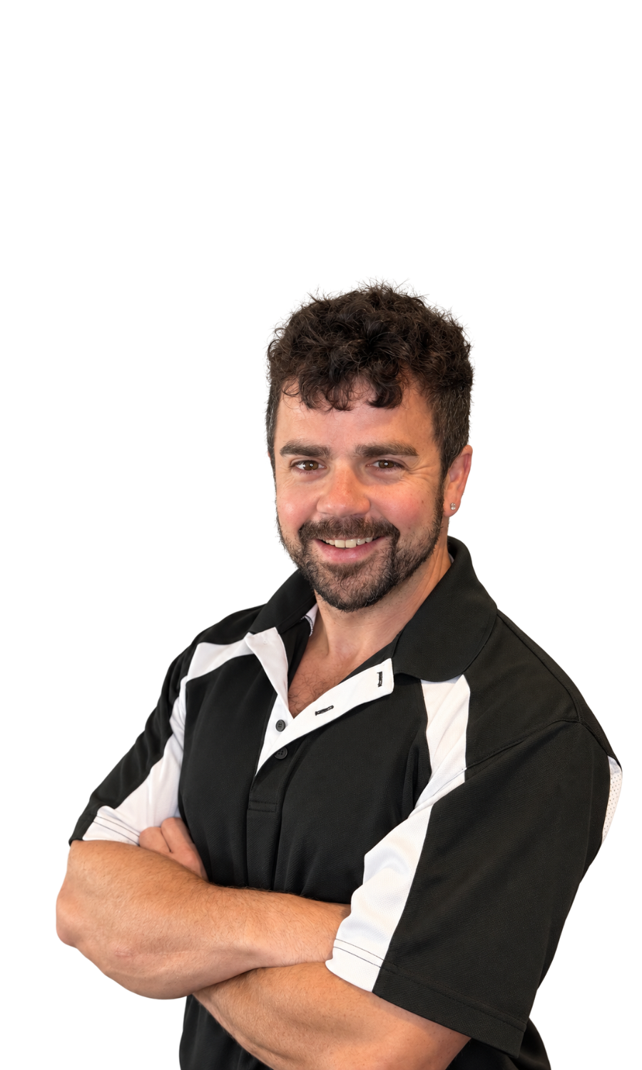 A man with curly dark hair and a beard, smiling and crossing his arms, wearing a black and white sports shirt.