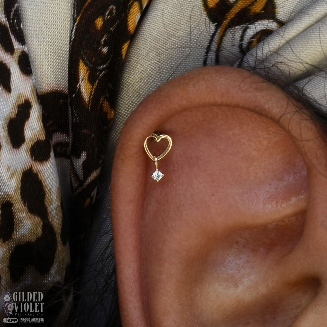 Sometimes it's the negative space that makes the most impact 🫶 in love with this heart dangle from our friends at @emberbodyjewelry 
.
.
.
#gildedvioletpiercing #jeannettepa #helixpiercing #piercings #curatedear
