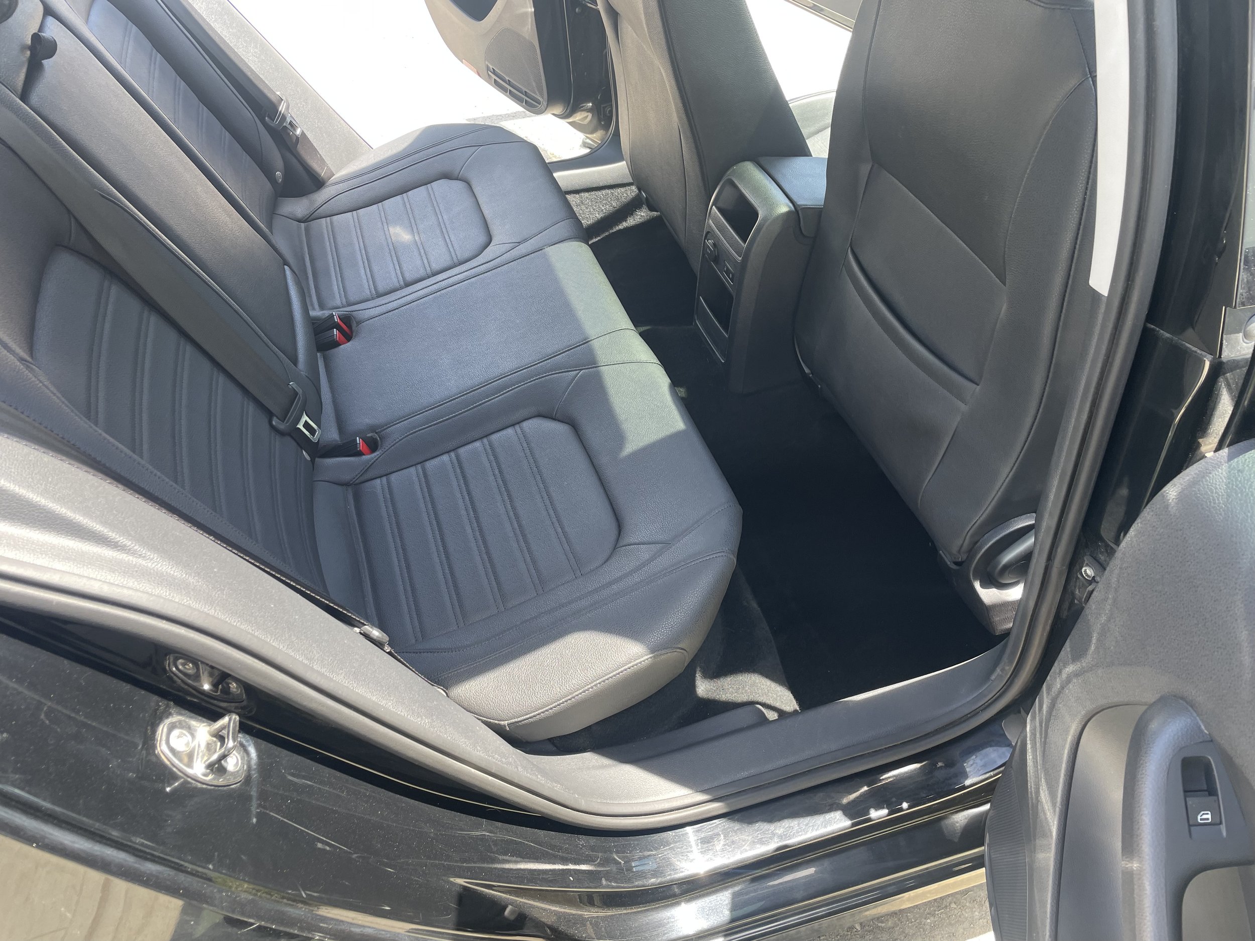 Car interior featuring black leather rear seats