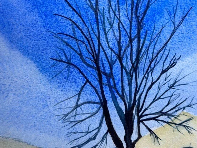 Bare tree branches against a vivid blue sky