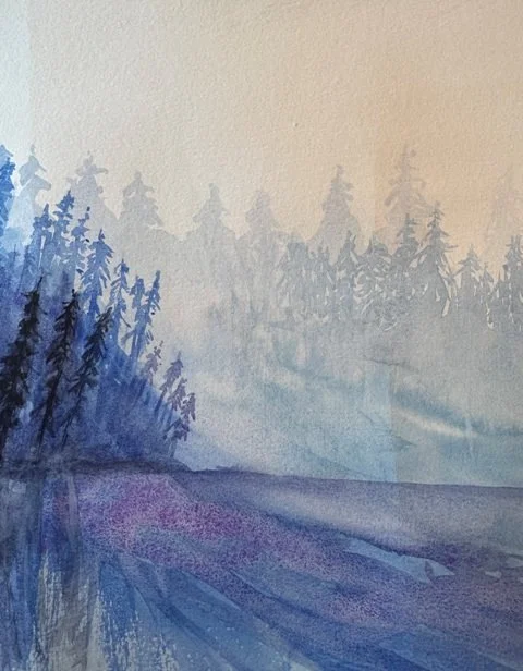 Close-up of dark pine trees fading into misty blue layers in “Still As Air."