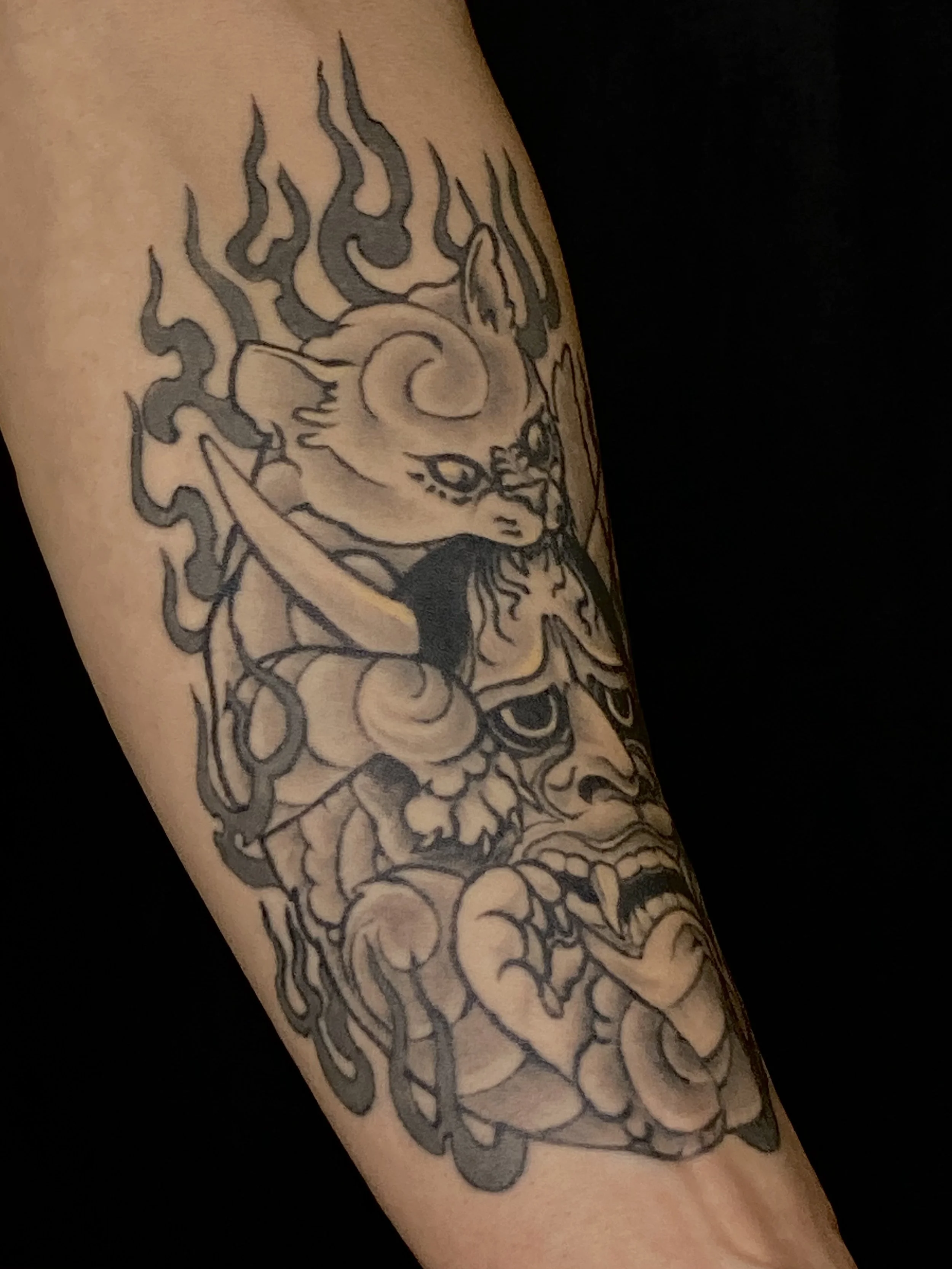 Tattoo of a dragon on a person's arm with flowing lines and shaded details.