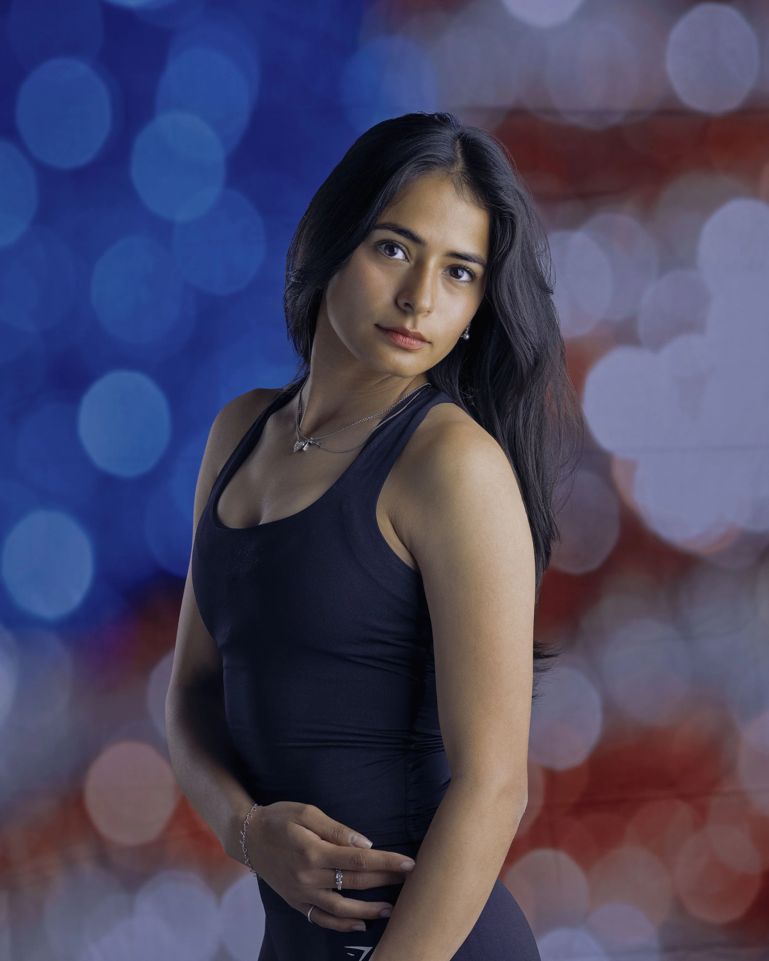 Creative portrait of a dark-haired woman against an intentionally blurred American flag background