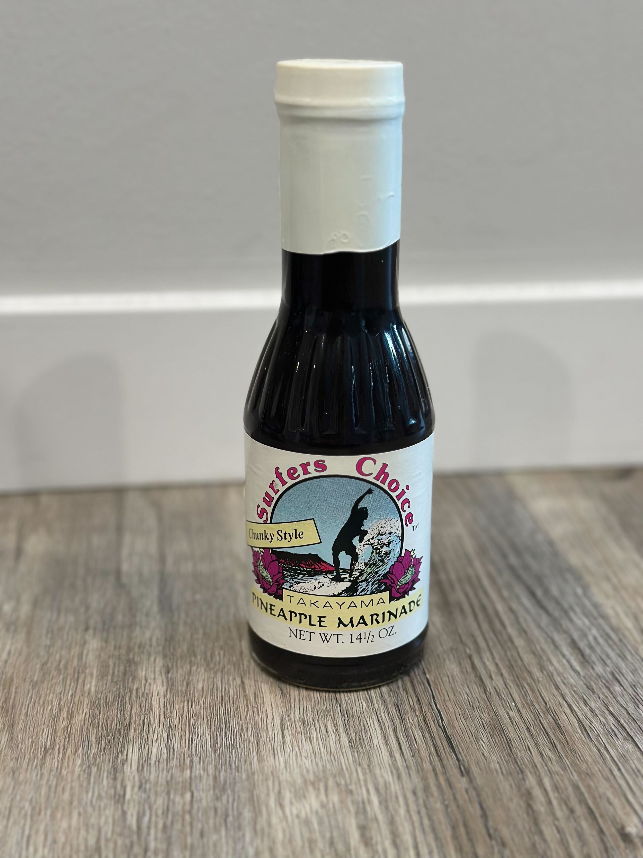 Bottle of Surfer's Choice Takayama Pineapple Marinade on wood surface