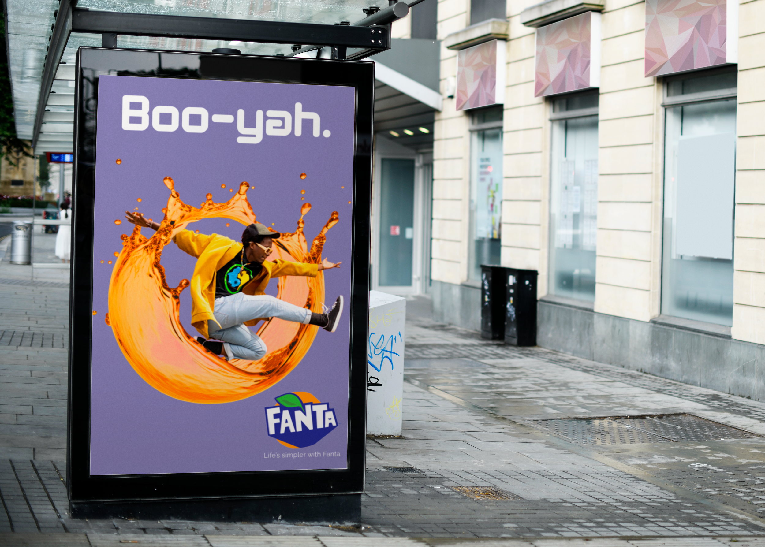 A Fanta advertisement on a bus stop showing a person mid-jump through a splash of orange liquid with the text "Boo-yah."