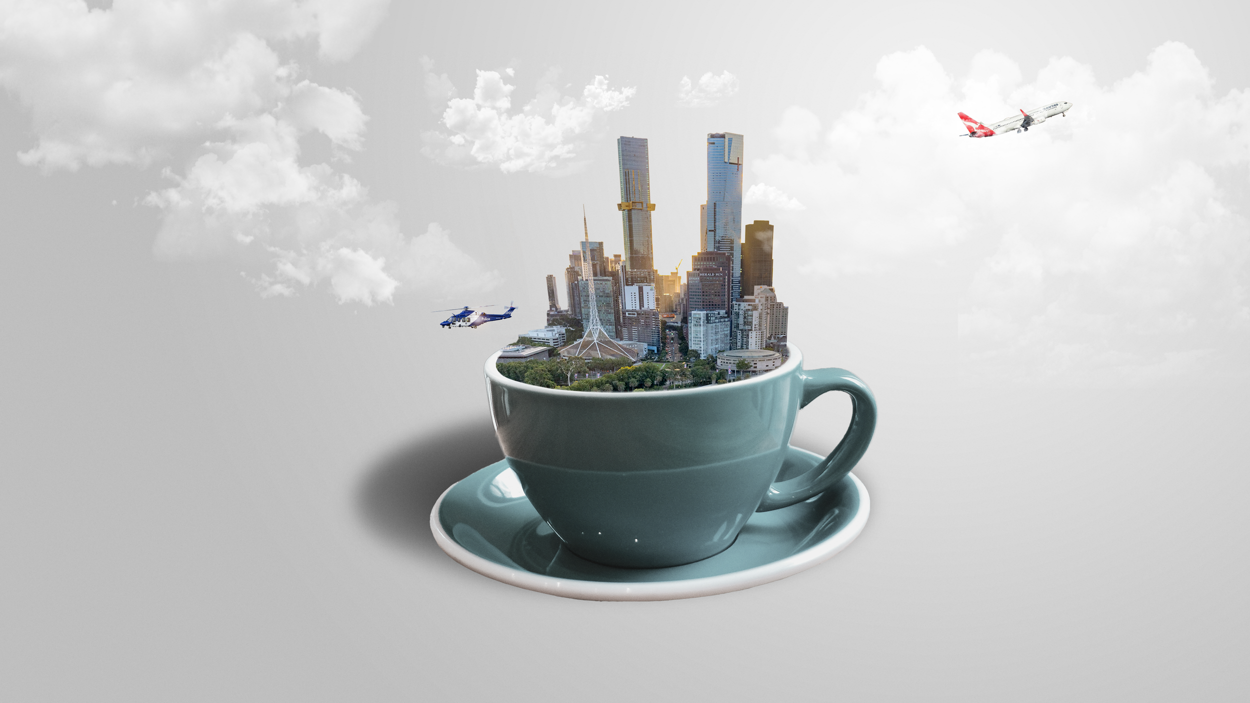 A large cup with a cityscape, including skyscrapers and trees, emerging from it, with airplanes flying in the sky above.