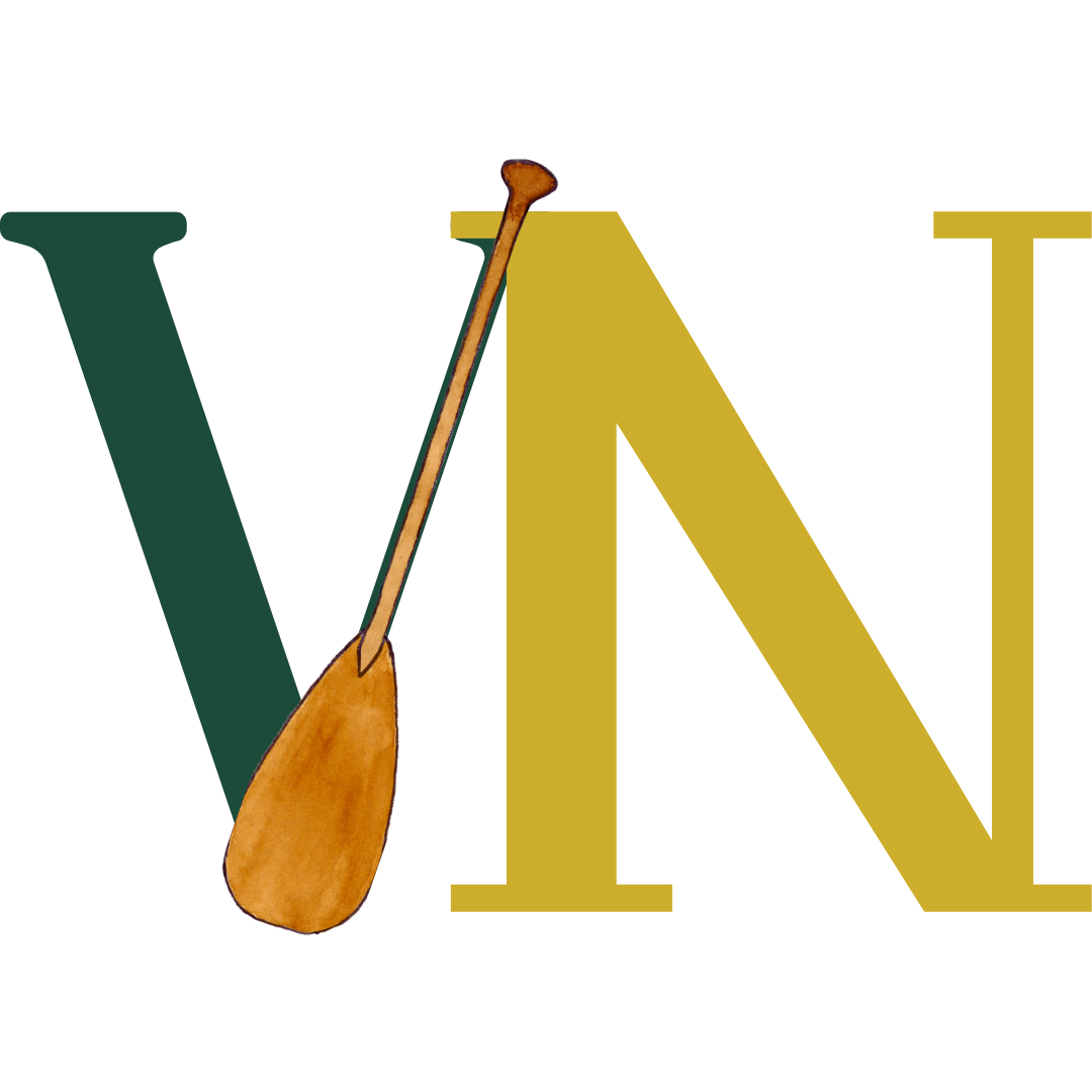 A wooden spoon resting against a yellow container with a purple lid.