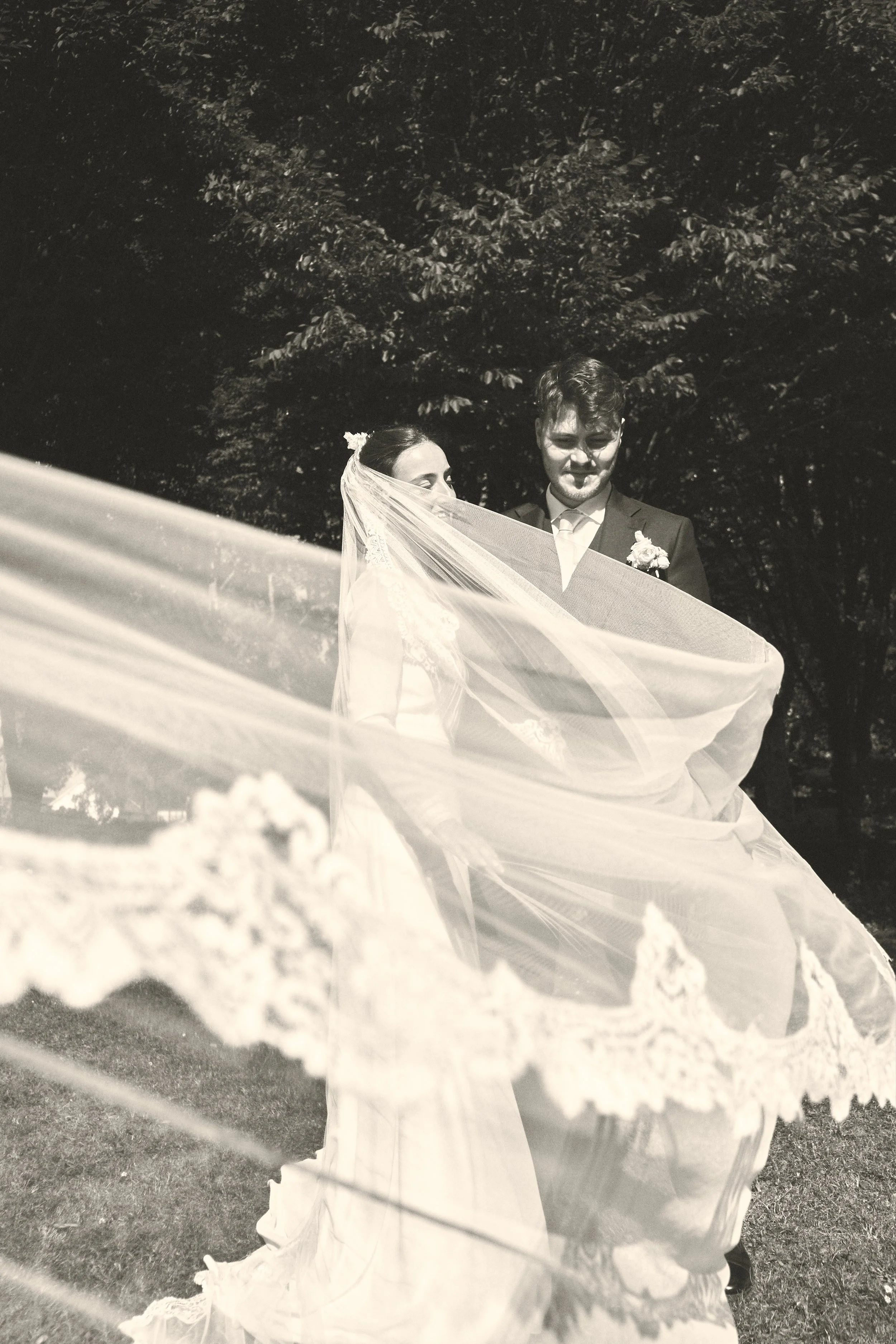 editorial wedding photograph of bride and groom framed by the brides veil