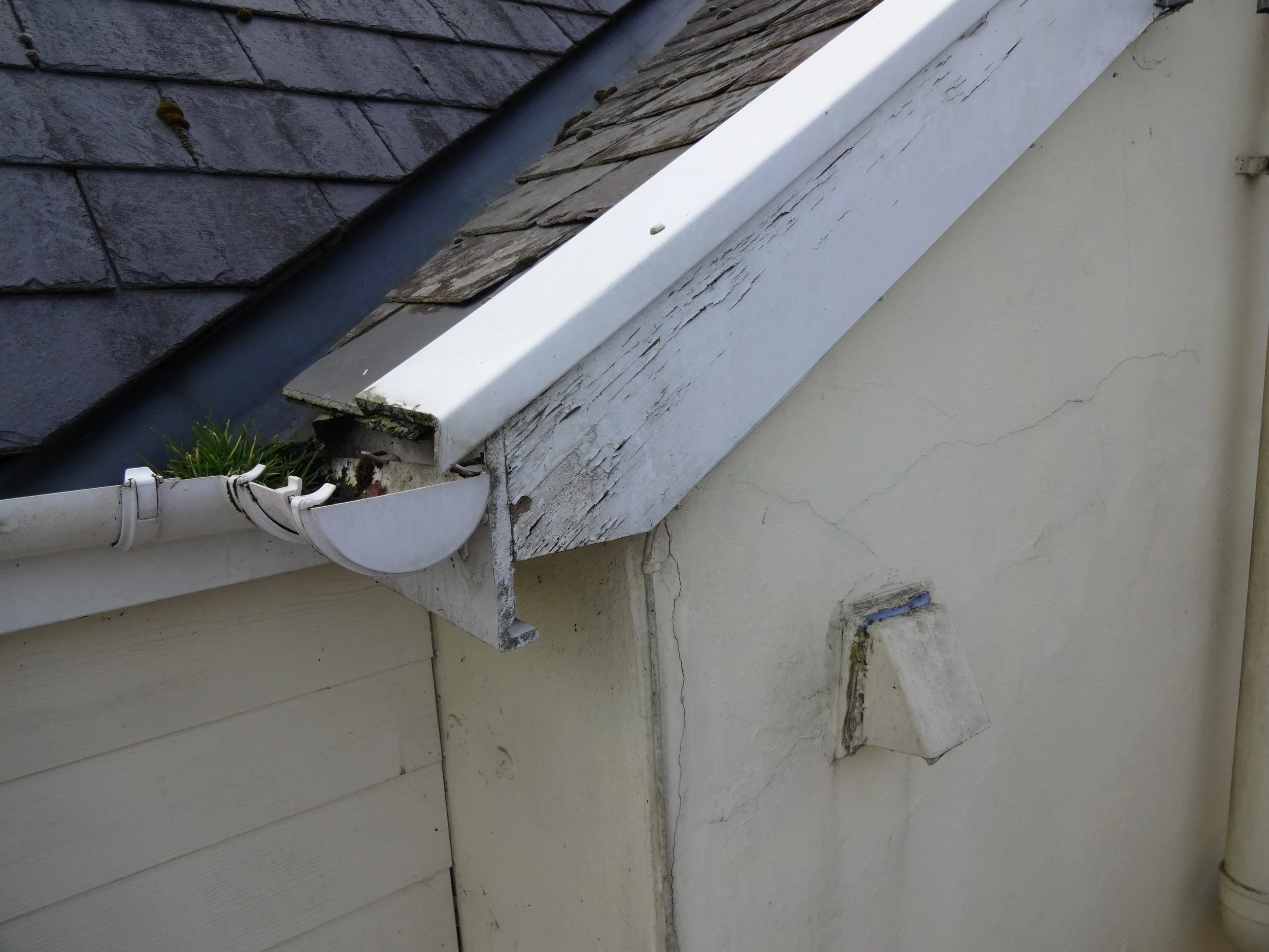 A lack of maintenance noted to the valley and barge boards and DIY repairs holding the tiles to the verge (edge) in place