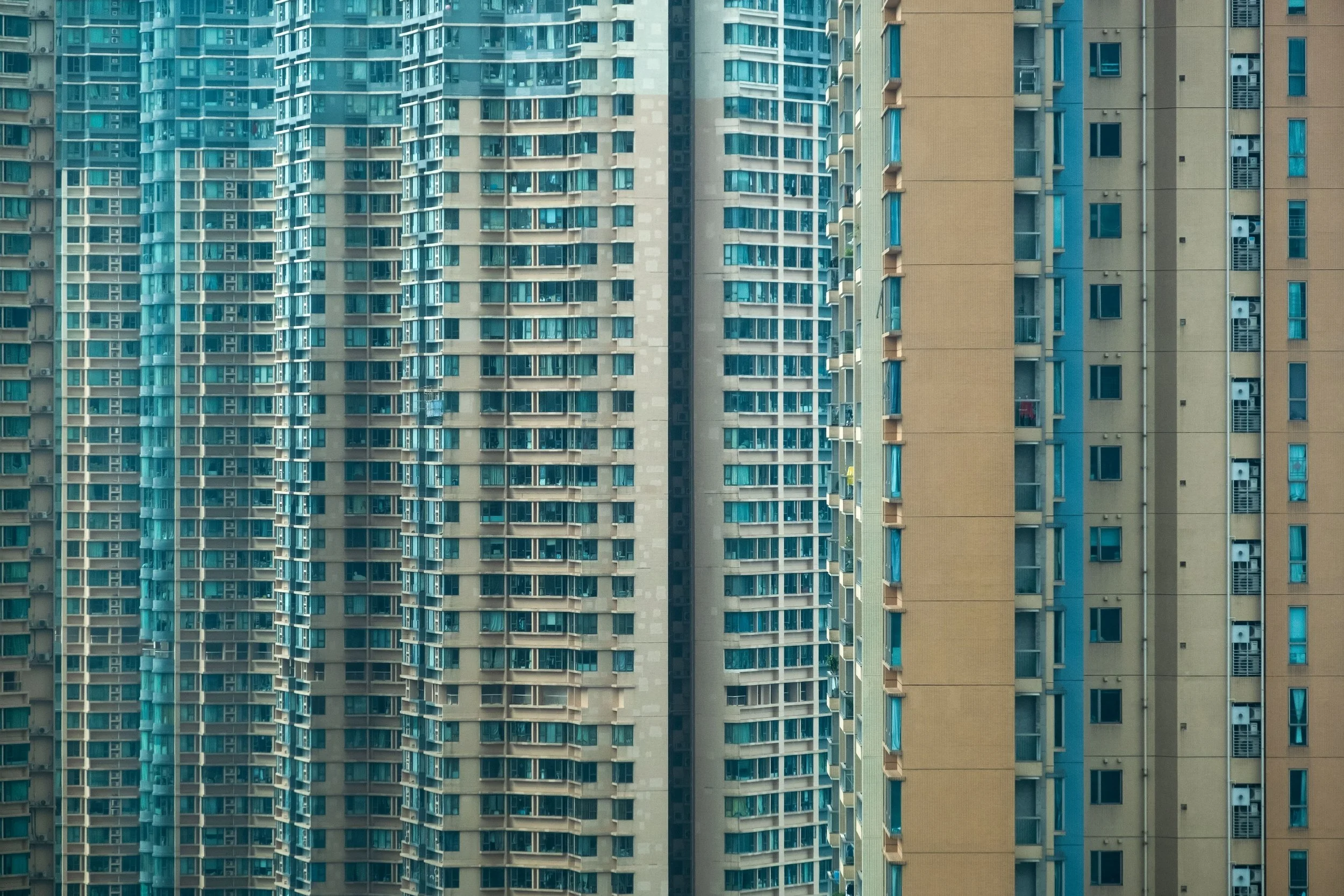 Close-up of multiple high-rise apartment buildings with glass windows and balconies.