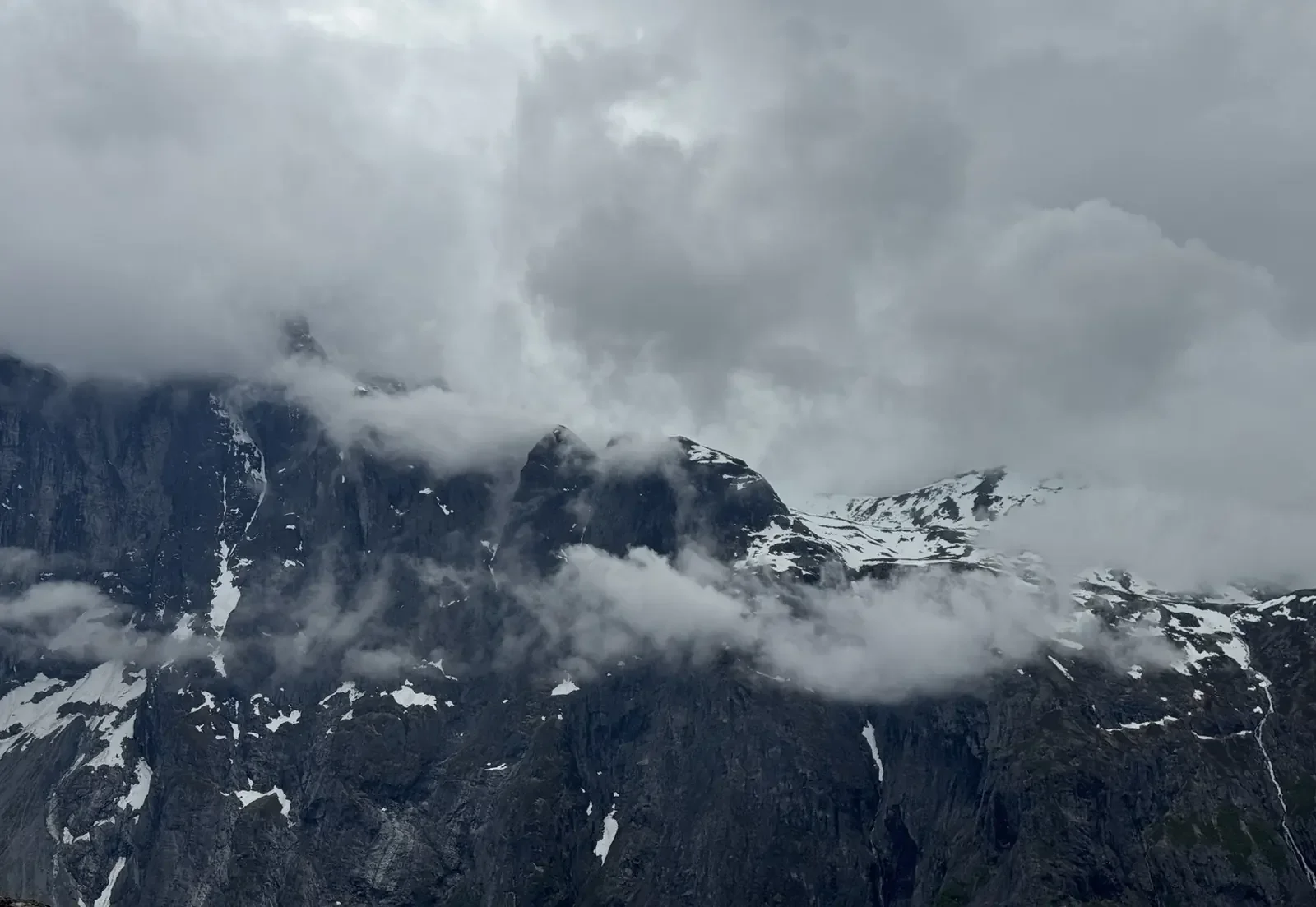 Cloud-covered mountain range with patches of snow