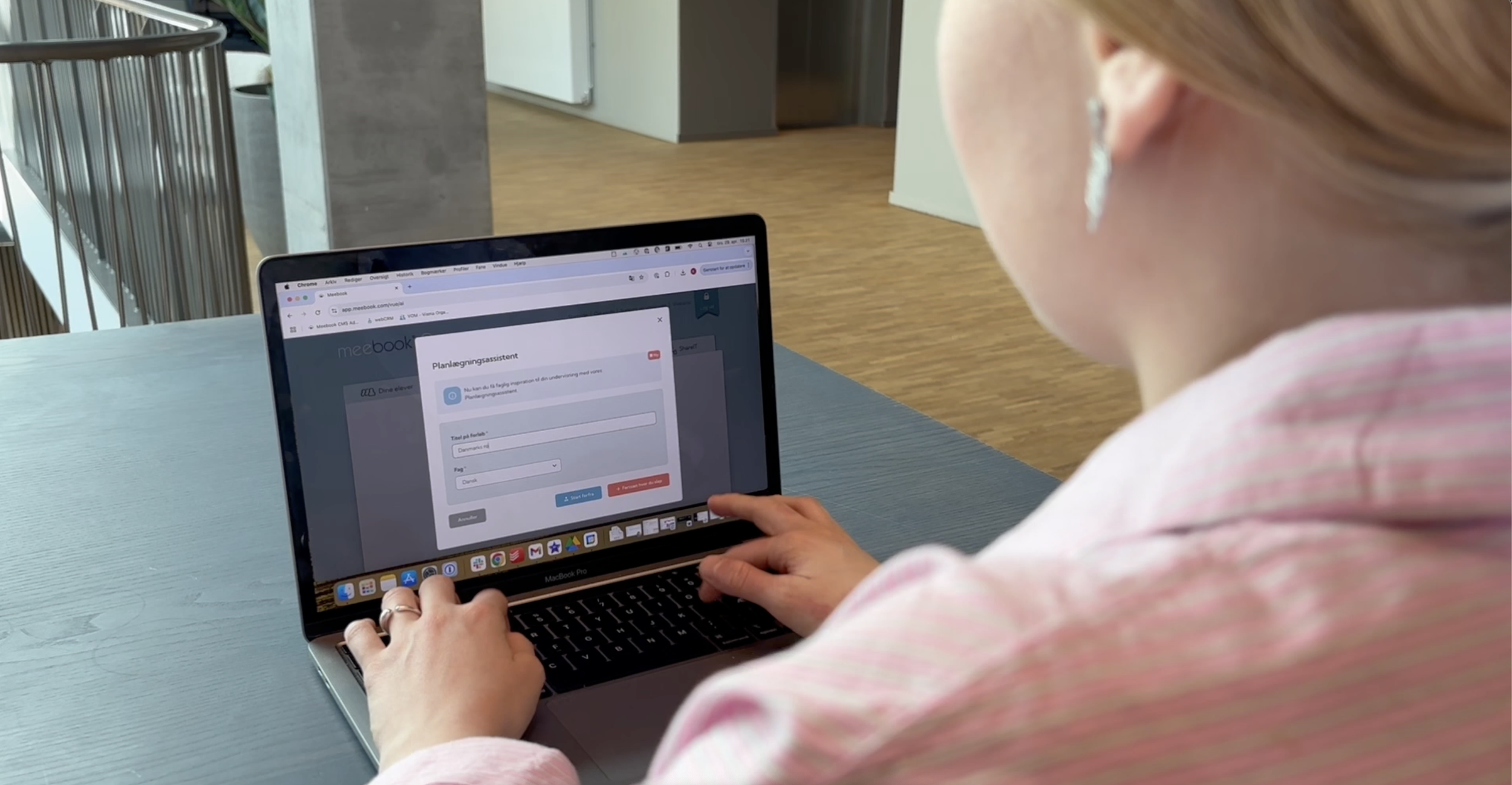 Kvindelig person bruger en bærbar computer med en планlægningsassistent på skærmen.