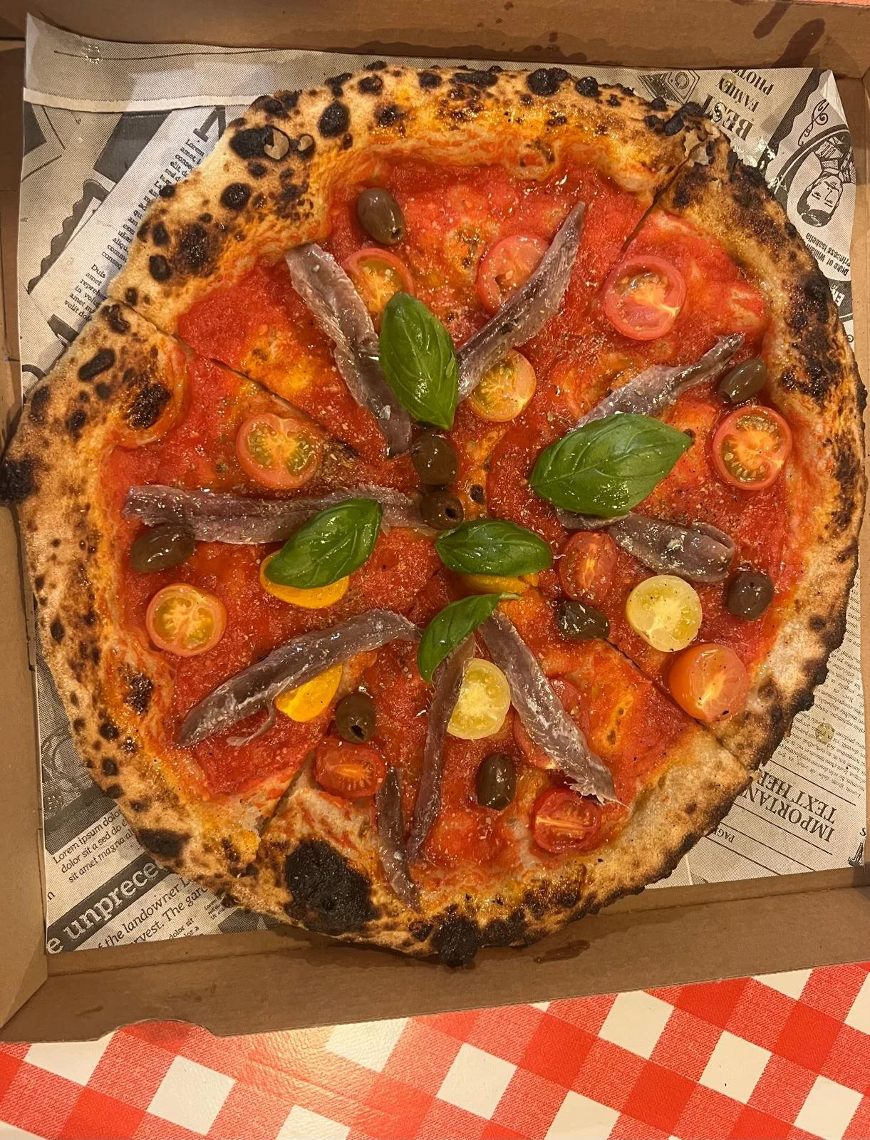 pizza avec Sauce tomate pelati Origan Olives taggiasche Tomates cerise Anchois gastronomiques Huile à l'ail Basilic frais