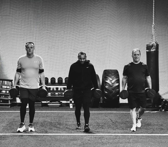 Upscale fitness class where trainer motivates clients during circuit workout 