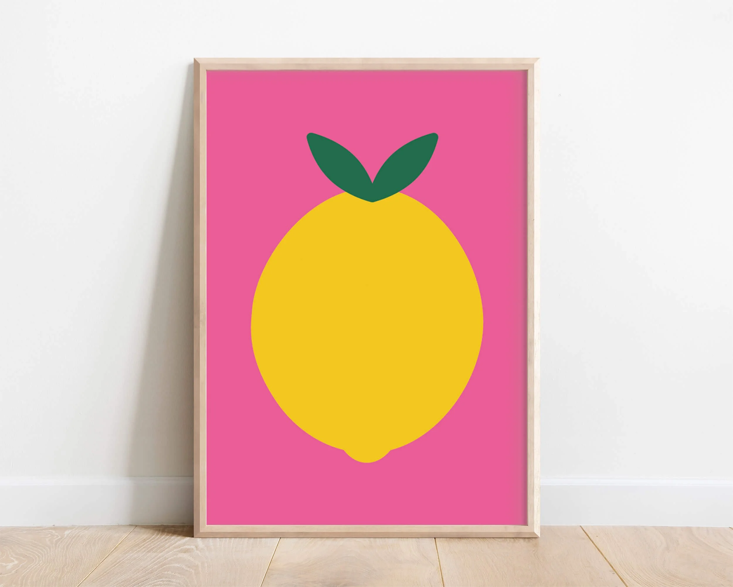 framed vibrant pink lemon print displayed against white interior wall