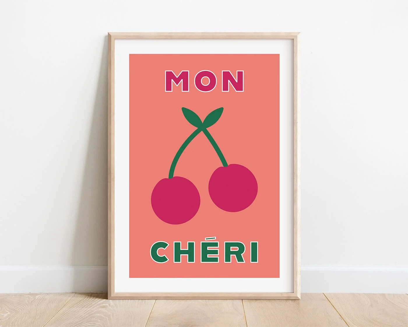 Pink Mon Cheri French typography print in a wooden frame displayed on a clean white gallery wall by Amatus