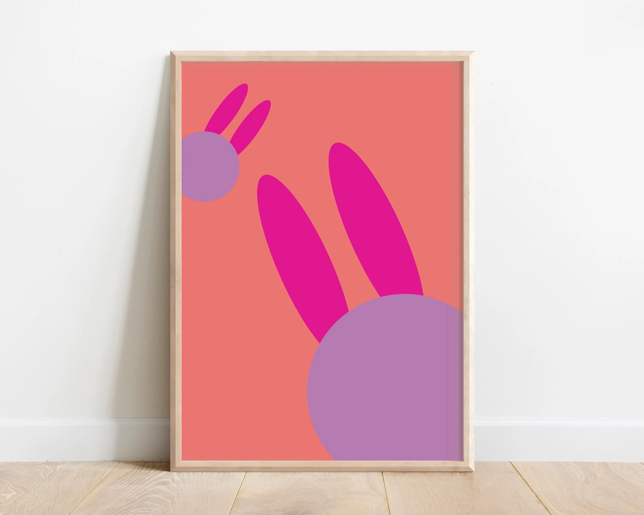Kids pink bunny wall art – framed animal print of two abstract bunny heads, nursery décor leaning against white wall with wooden floor, UK children’s room artwork
