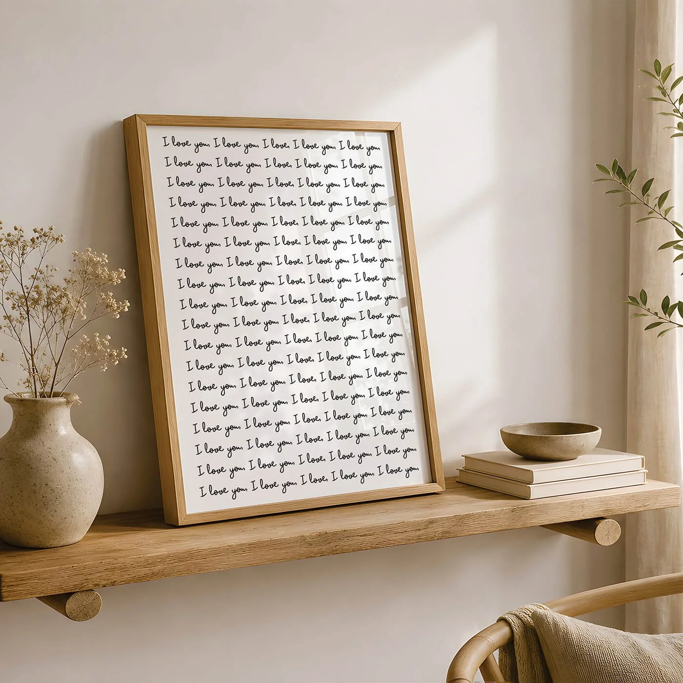 Black and White I Love You Print in a modern wooden frame displayed on a wooden sideboard beside a contemporary lamp and leafy plant.