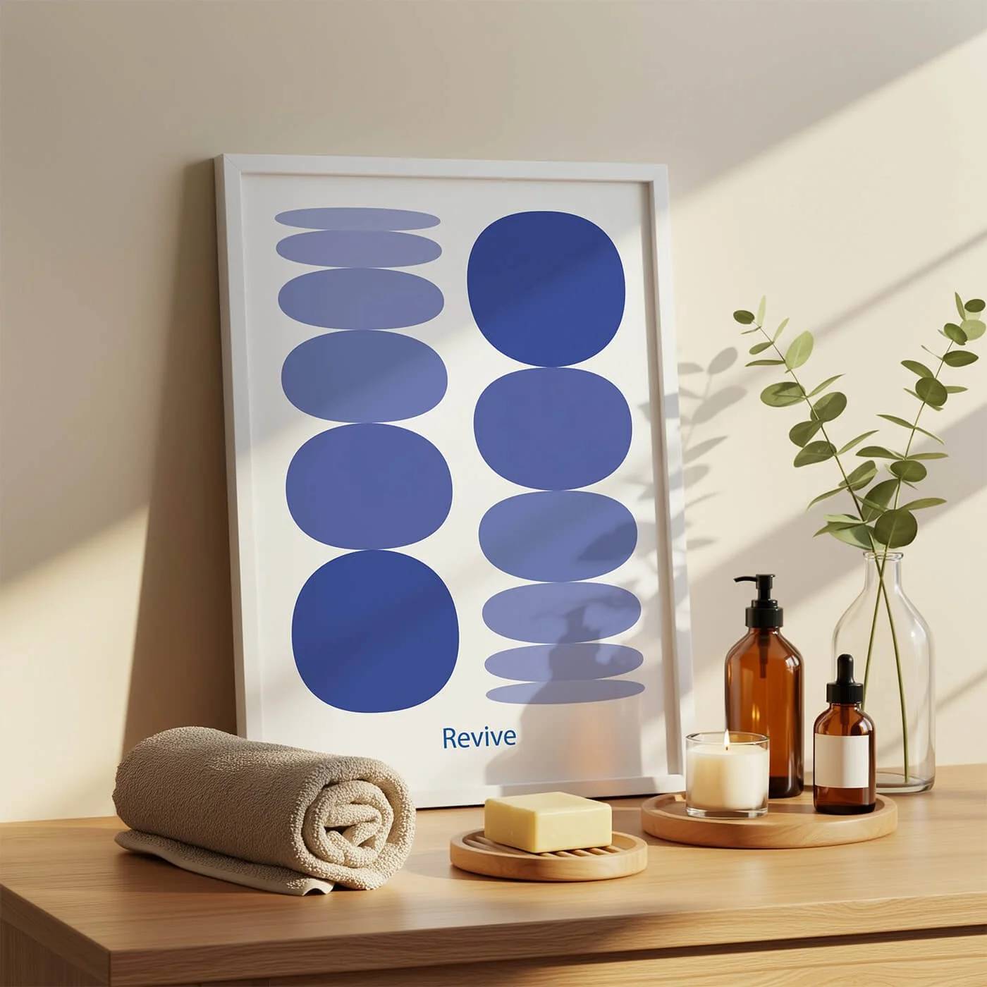 Framed modern art print titled Revive, showcasing a vertical composition of stacked blue pebble shapes in a bright room setting