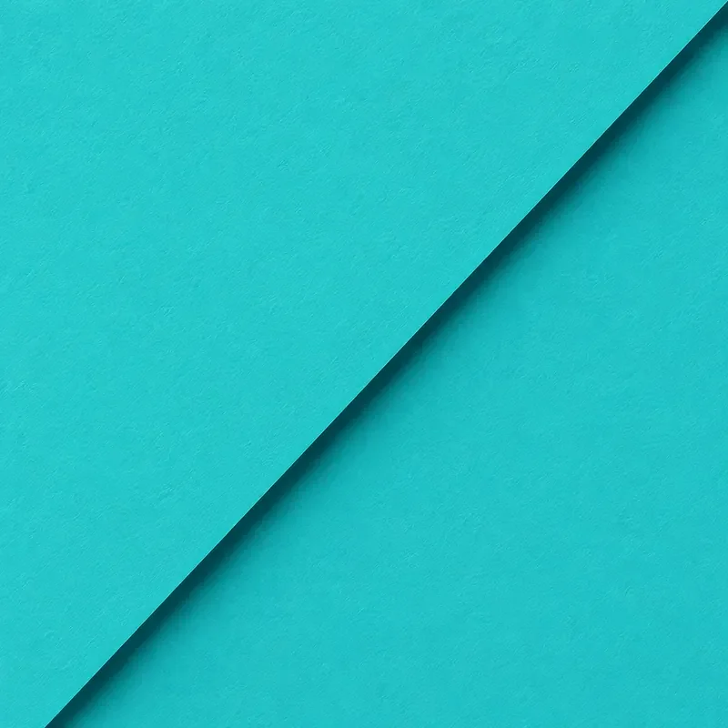 Close-up of layered cyan-colored paper with a diagonal fold.