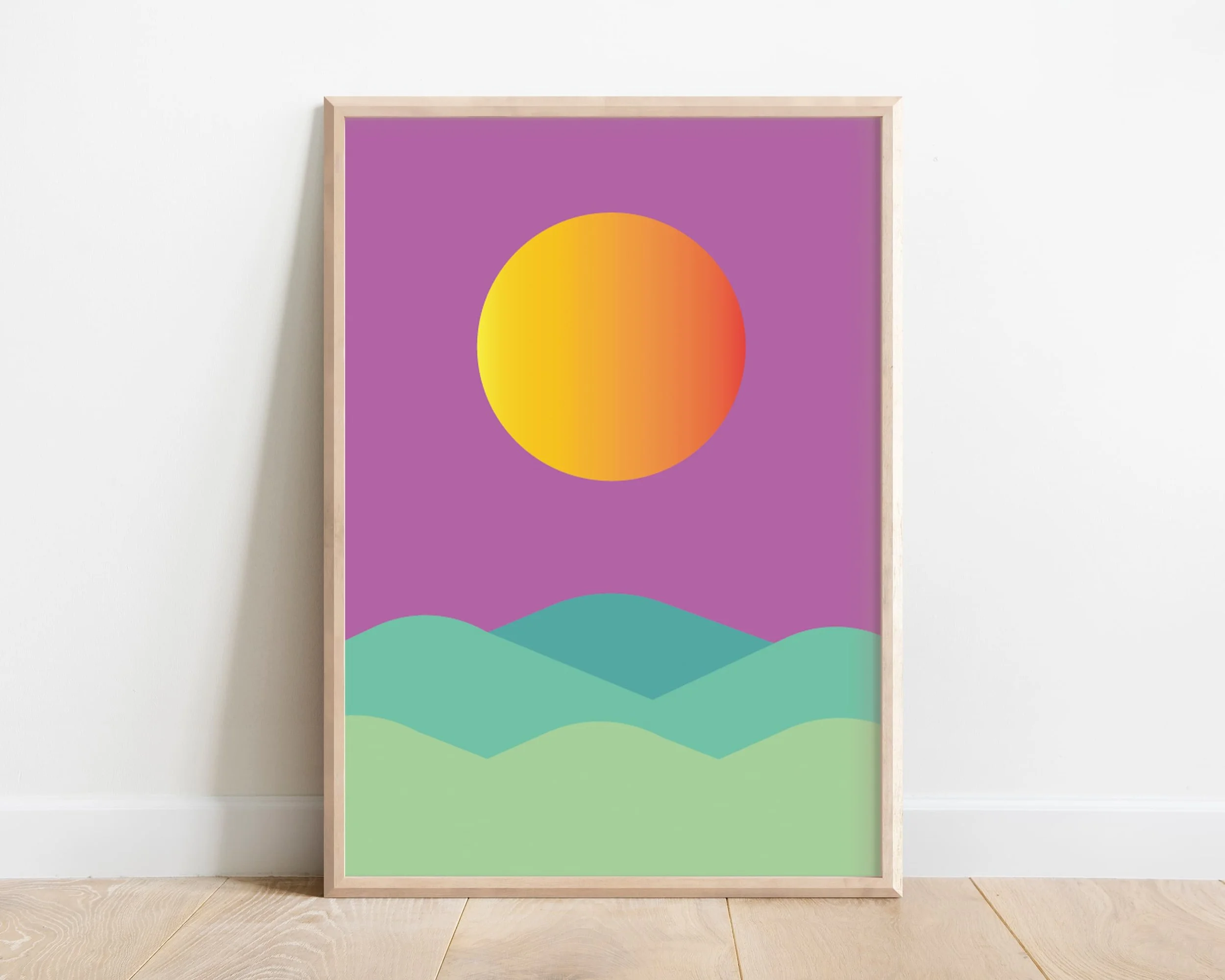 Purple themed abstract sun print with green hills and blue sky displayed in wooden frame and leaning against modern interior wall