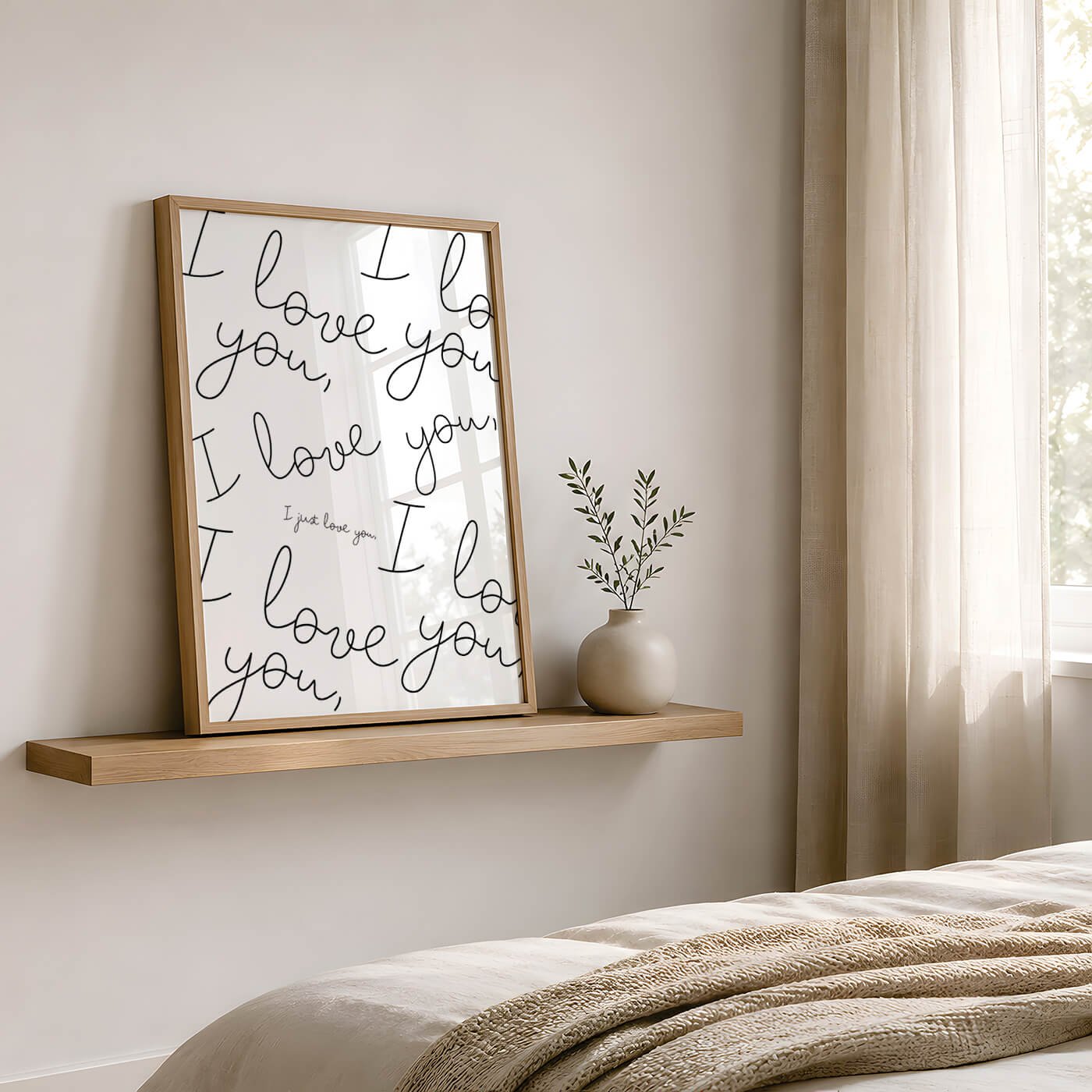 contemporary framed print saying the words 'i love you' in a stylish typhography font displayed on a wooden shelf in a modern bedroom opposite a beige covered bed