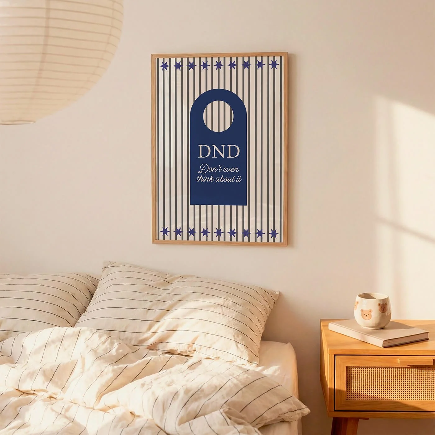framed blue poster with the words do not disturb, displayed on wall in white bedroom