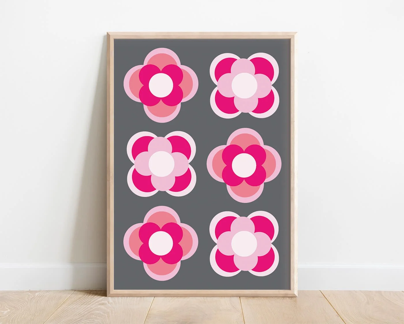 Pink contemporary flower print in a light wooden frame against a white background