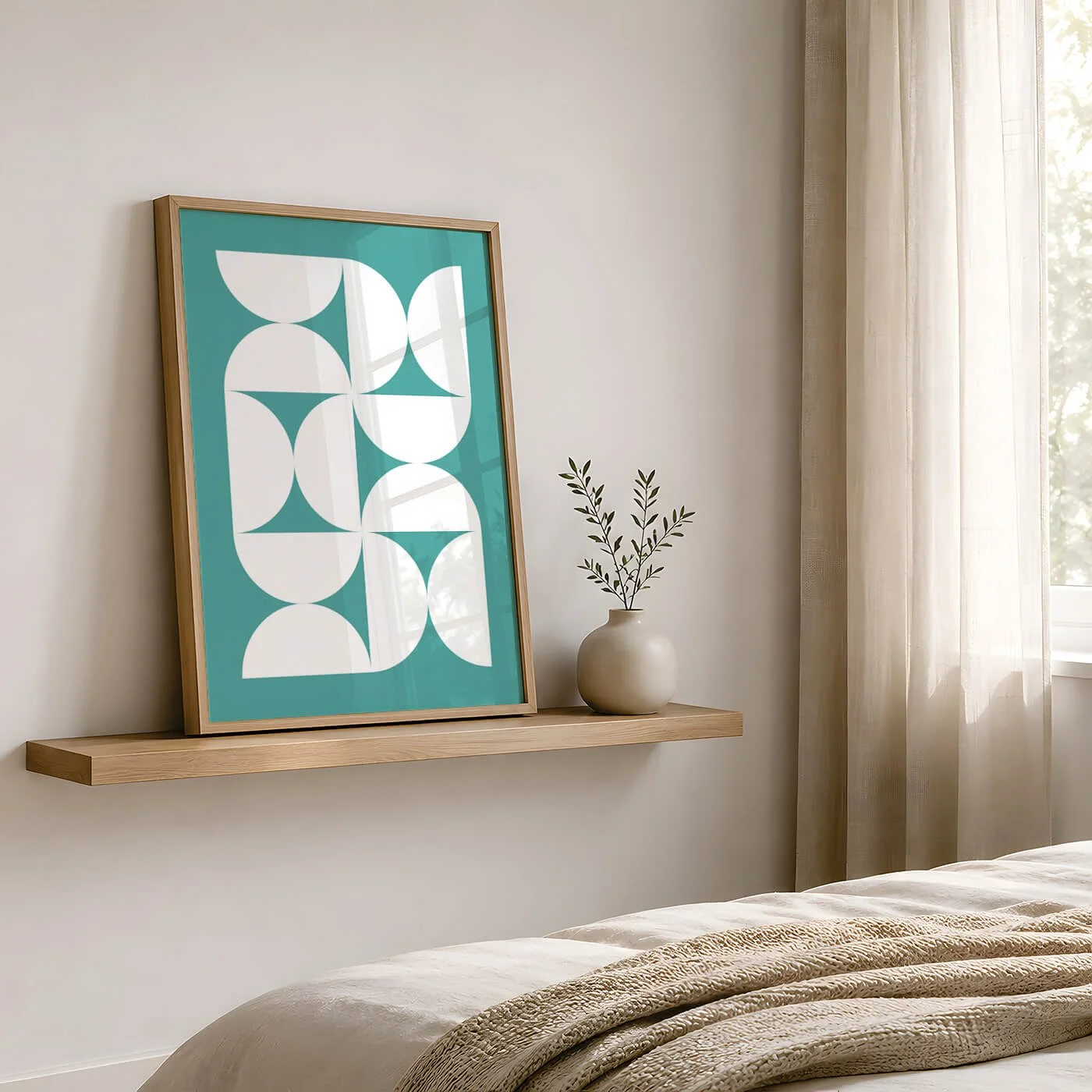 A minimalist bedroom corner with a wooden shelf holding a framed teal and white geometric print and a white ceramic vase with green leaves, near a window with light cream curtains.