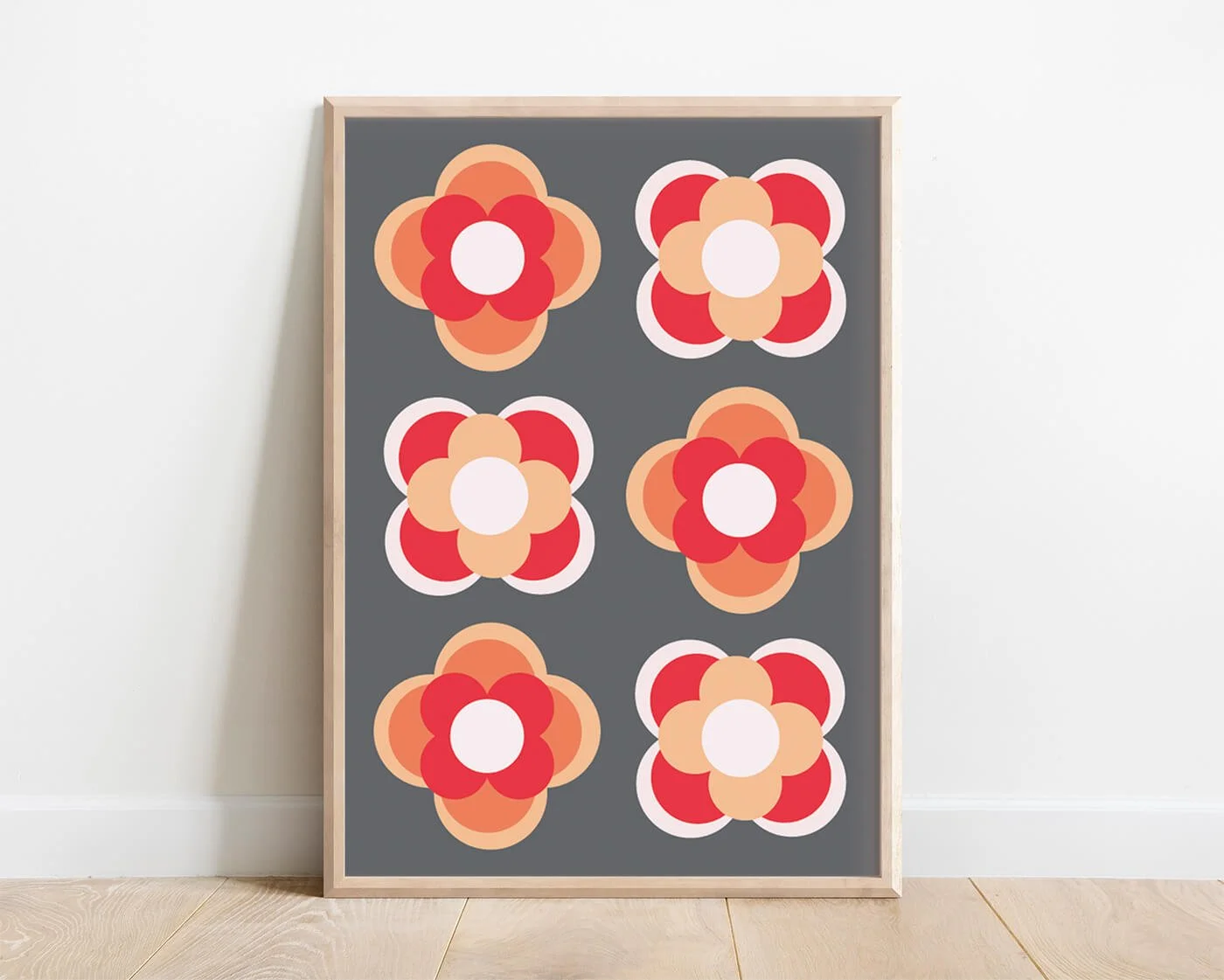 Orange contemporary flower print in a light wooden frame against a white background