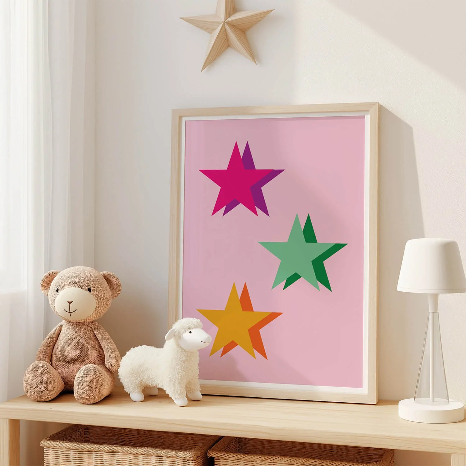 Framed pink star print in childrens bedroom displayed on shelf