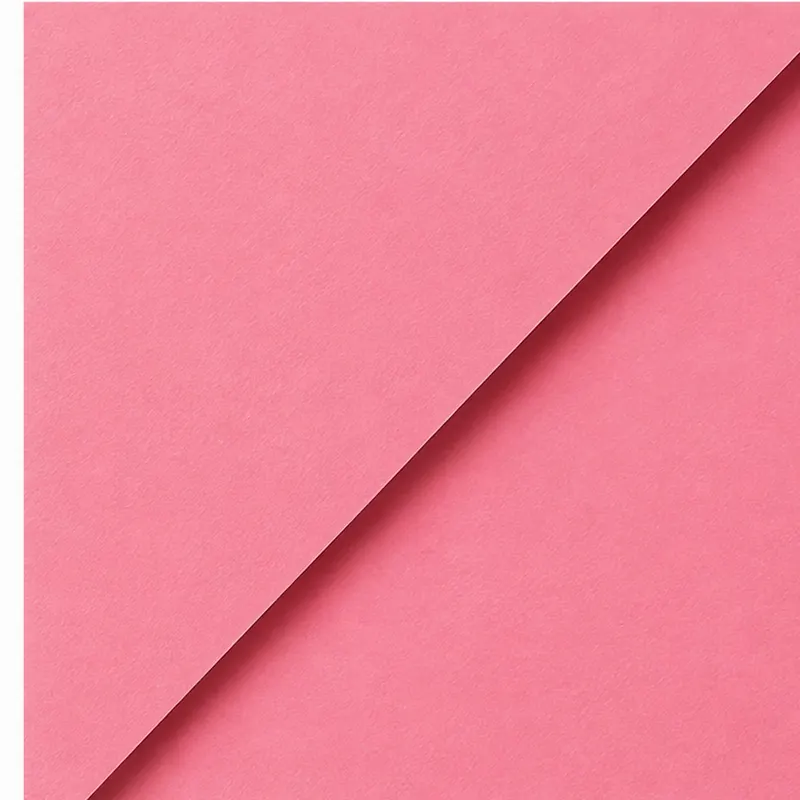 Close-up photo of pink paper with one corner curled.