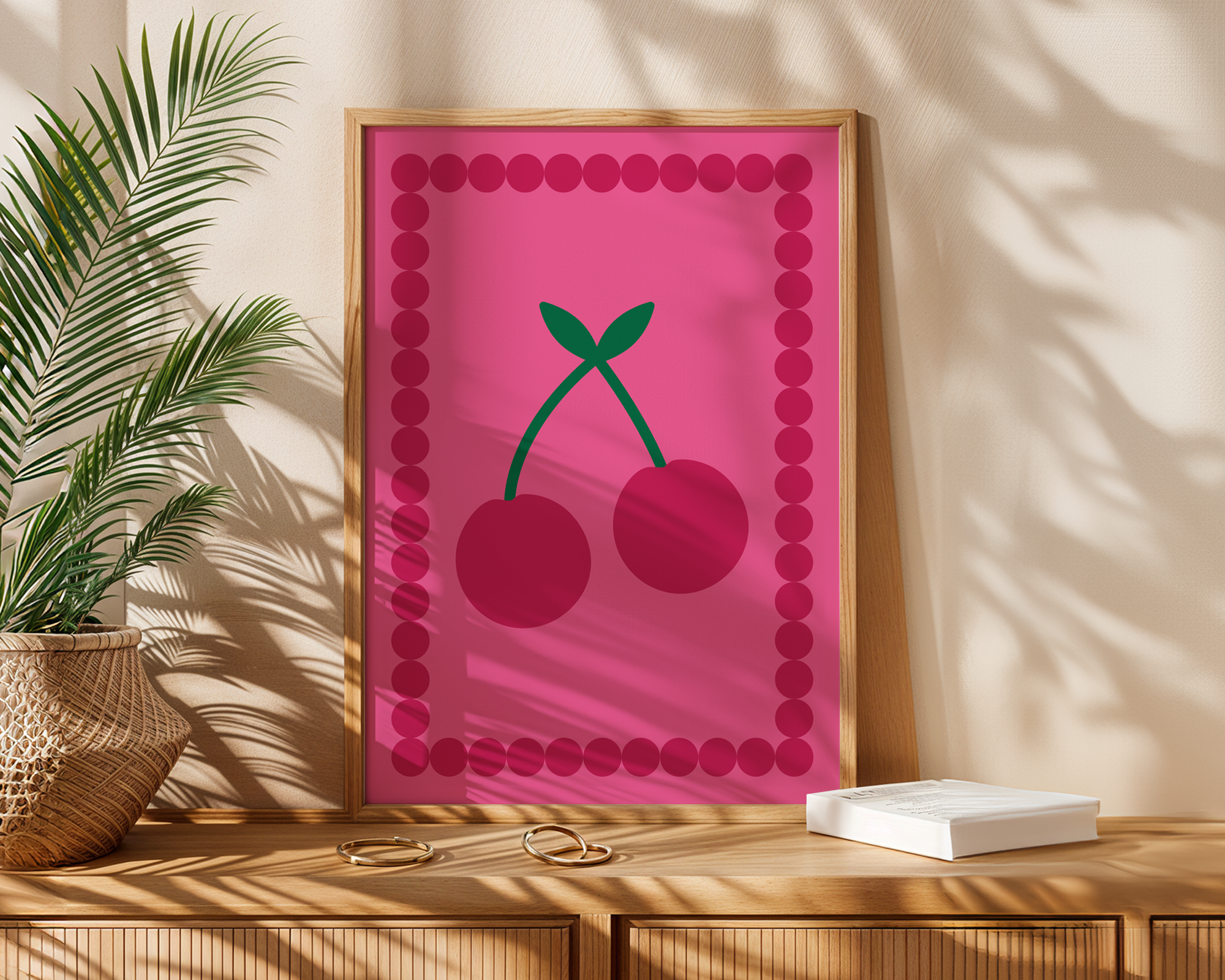pink cherry print with decorative frame on table next to plant