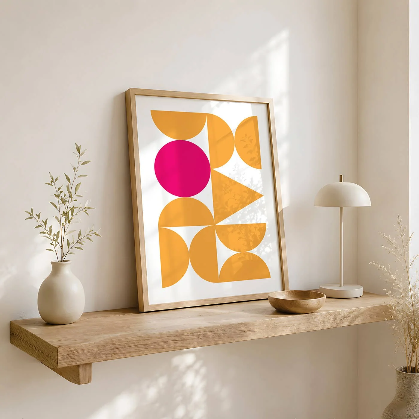 Framed picture of a bauhaus style print in yellow displayed on scandi style wooden cabinet