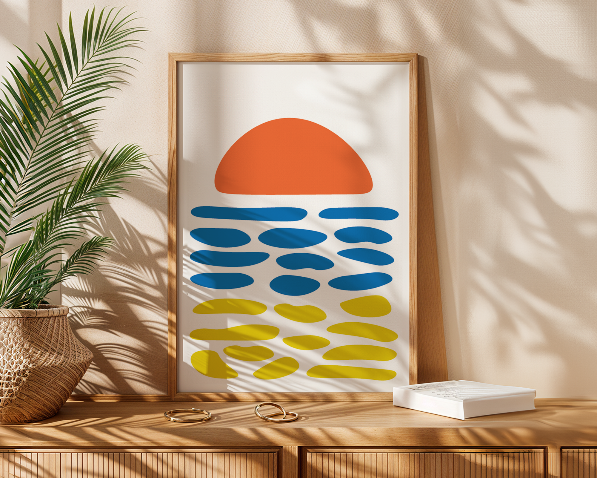 abstract beach print in frame next to plant